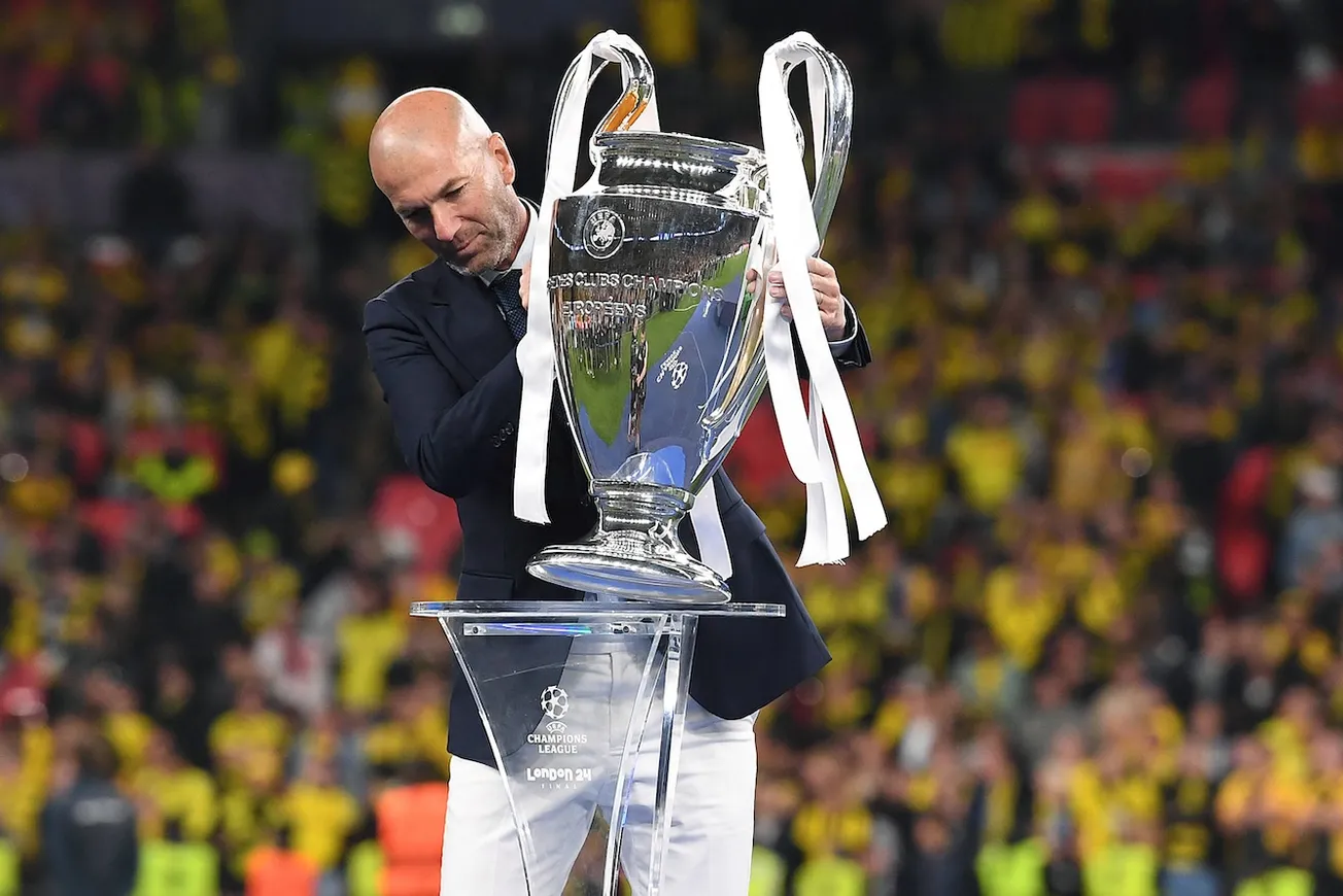 Zinedine Zidane rückt den Champions-League-Pokal zurecht. Foto: Imago / Revierfoto